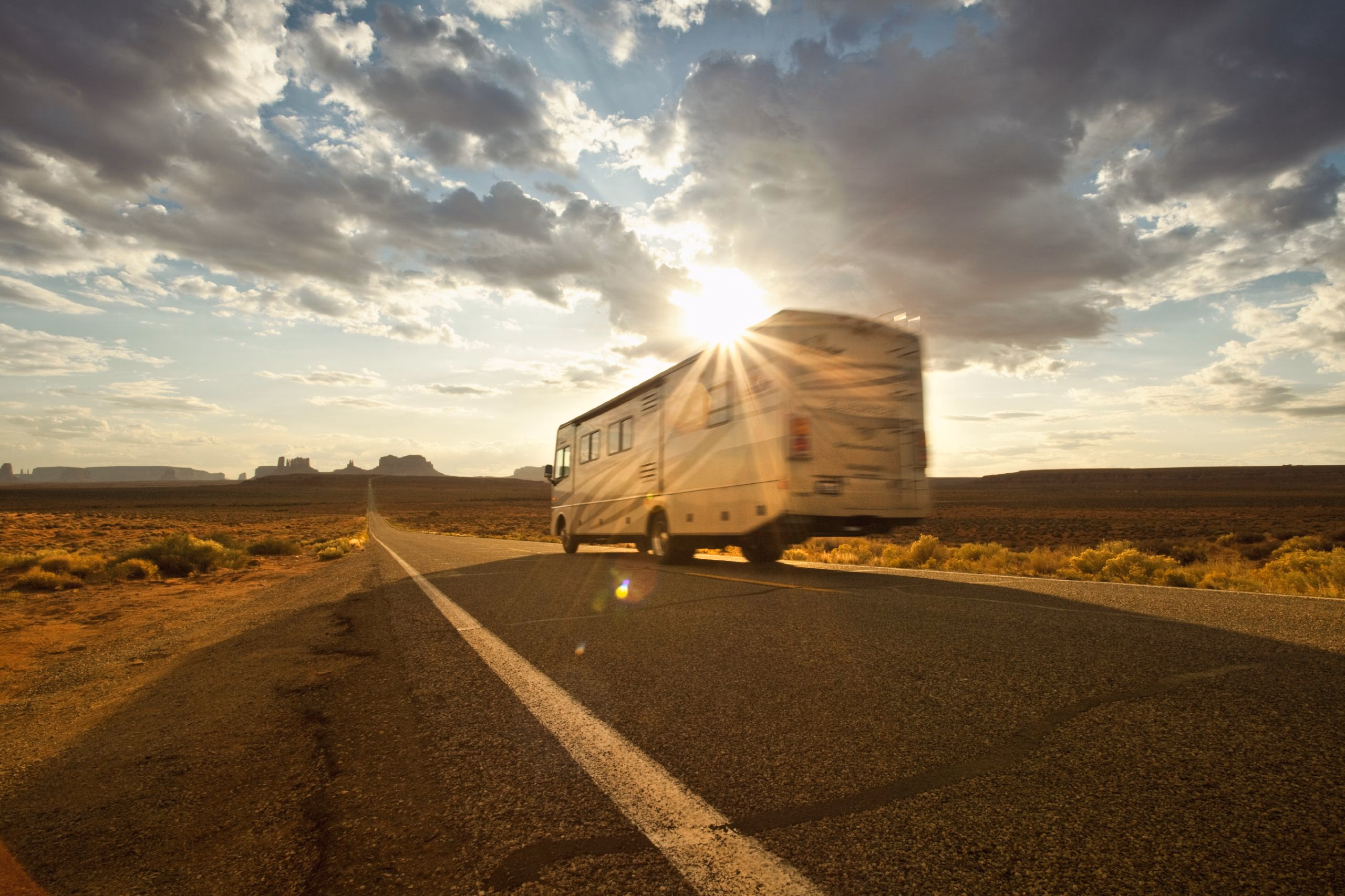 RV Driving down a road in the plains