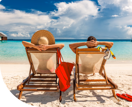 Couple relaxing on lounge chairs oceanside