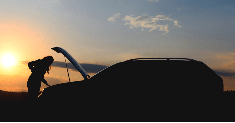 person looking under hood of their vehicle